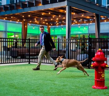 A resident plays with his dog in the on-site bark park